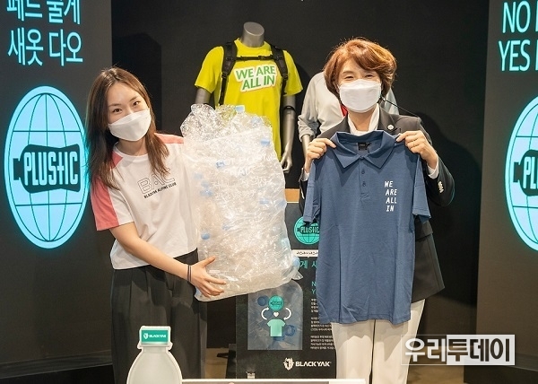 한정애 환경부장관(오른쪽)이 지난 5월 26일 ‘2021 P4G 서울 녹색미래정상회의’ 녹색미래주간 행사의 일환으로 개최된 ‘투명페트병 가져오면 티셔츠 드려요’ 행사에 참석해 투명페트병 15개를 재활용 의류와 교환하고 있다. (사진제고=환경부)