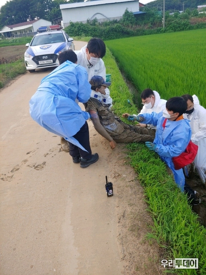 논으로 추락한 전동휠체어 탑승장애인을 구조하고있는 경찰. (사진제공=강화경찰서)