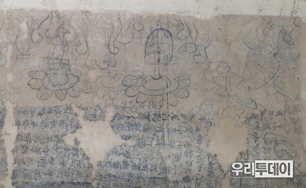 경주 남산 출토로 전해지는 범자본 수구다라니의 부분. 연꽃무늬와 정병의 도상들을 글자위에 그려 놓았다. 