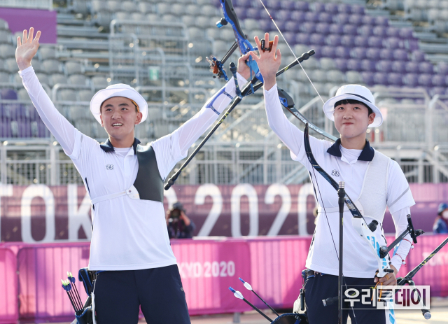 양궁 국가대표 김제덕(왼쪽)과 안산이 24일 일본 도쿄 유메노시마 공원 양궁장에서 열린 도쿄올림픽 혼성 결승전에서 금메달을 획득한 후 손을 흔들어 인사하고 있다. (사진제공=연합뉴스)