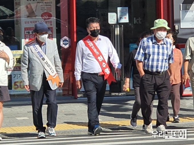 경산시장 횡단보도를 걷고있는 허수영 경북도당 경산시지회장 (사진=박현정기자)