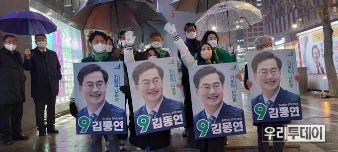 홍대앞에서 비가 오는 가운데 새로운물결 김동연 후보자의 자원봉사자들이 유세를 하고있다.