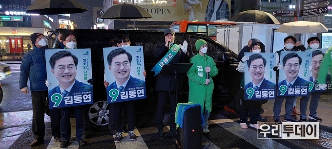 자원봉사자들이 홍대앞에서 비가 오는 가운데에서 선거유세를 하고 있다