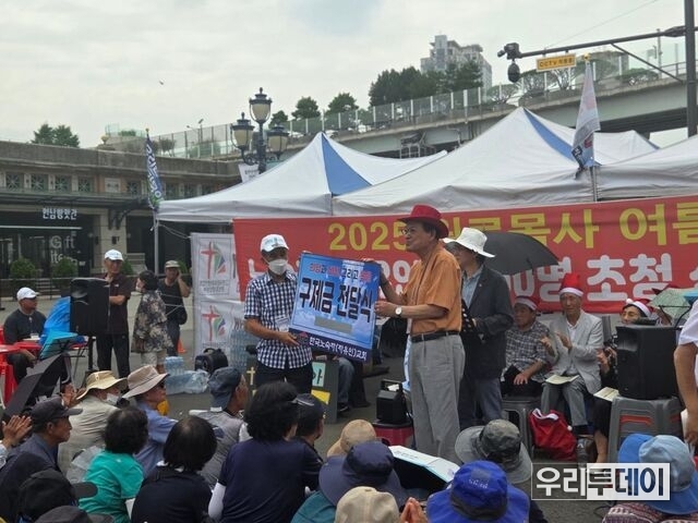11일 서울역 광장에서 열린 ‘원로목사 여름산타 노숙자 초청 선물 및 구제금 전달식’에서 김호일 목사가 노숙인 반장에게 대표로 구제금을 전달하고 있다. 서울역쪽방상담소 제공